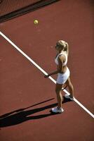 giovane donna giocare a tennis all'aperto foto