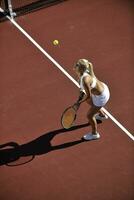 giovane donna giocare a tennis all'aperto foto