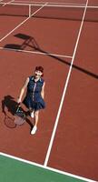 giovane donna giocare a tennis all'aperto foto