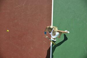 giovane donna giocare a tennis all'aperto foto