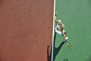 giovane donna giocare a tennis all'aperto foto