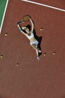 giovane donna giocare a tennis all'aperto foto