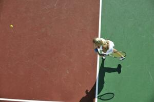 giovane donna giocare a tennis all'aperto foto