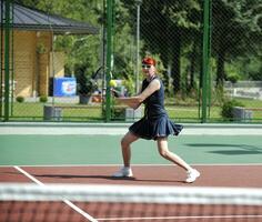 giovane donna giocare a tennis all'aperto foto