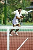 il giovane gioca a tennis all'aperto foto