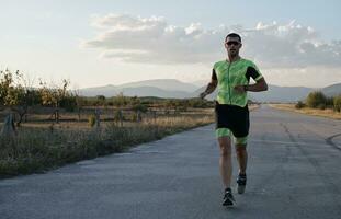 atleta di triathlon che corre durante l'allenamento mattutino foto