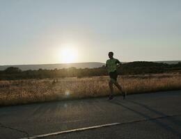 atleta di triathlon che corre durante l'allenamento mattutino foto