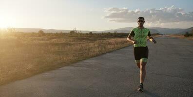 atleta di triathlon che corre durante l'allenamento mattutino foto