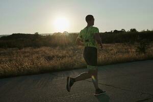 atleta di triathlon che corre durante l'allenamento mattutino foto