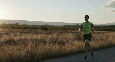 atleta di triathlon che corre durante l'allenamento mattutino foto