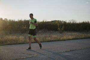 atleta di triathlon che corre durante l'allenamento mattutino foto