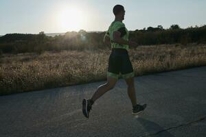 atleta di triathlon che corre durante l'allenamento mattutino foto