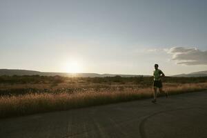 atleta di triathlon che corre durante l'allenamento mattutino foto