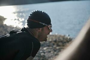 atleta di triathlon che inizia l'allenamento di nuoto sul lago foto