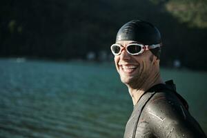 atleta di triathlon che inizia l'allenamento di nuoto sul lago foto