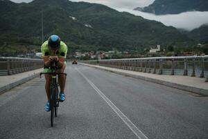 atleta di triathlon in sella a una bicicletta durante l'allenamento mattutino foto