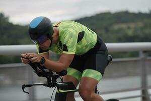 atleta di triathlon in sella a una bicicletta durante l'allenamento mattutino foto