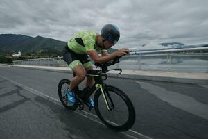 atleta di triathlon in sella a una bicicletta durante l'allenamento mattutino foto