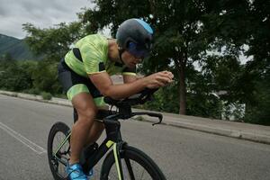 atleta di triathlon in sella a una bicicletta durante l'allenamento mattutino foto