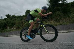 atleta di triathlon in sella a una bicicletta durante l'allenamento mattutino foto