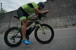 atleta di triathlon in sella a una bicicletta durante l'allenamento mattutino foto