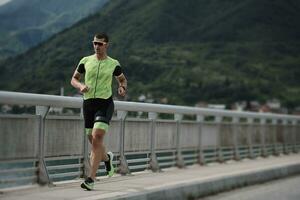 atleta di triathlon che corre su strada foto