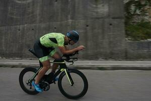 atleta di triathlon in sella a una bicicletta durante l'allenamento mattutino foto