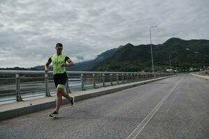 atleta di triathlon che corre su strada foto