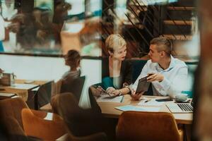 contento uomini d'affari sorridente allegramente durante un' incontro nel un' caffè negozio. gruppo di riuscito attività commerciale professionisti Lavorando come un' squadra nel un' multiculturale posto di lavoro. foto