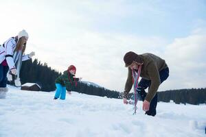 contento famiglia giocando insieme nel neve a inverno foto