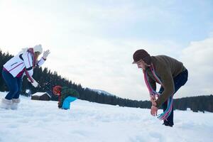 contento famiglia giocando insieme nel neve a inverno foto