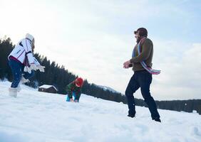 contento famiglia giocando insieme nel neve a inverno foto