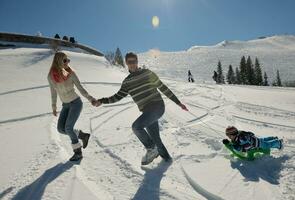 famiglia avendo divertimento su fresco neve a inverno vacanza foto
