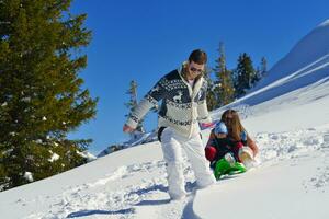 famiglia avendo divertimento su fresco neve a inverno vacanza foto