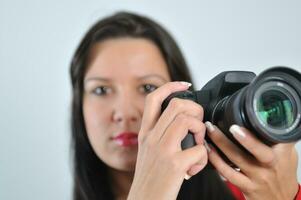 giovane donna Tenere telecamera nel mano assunzione immagine isolato foto