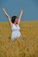 giovane donna nel campo di grano in estate foto