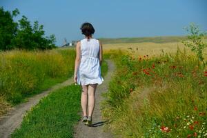 giovane donna nel campo di grano in estate foto