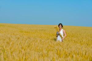 giovane donna nel campo di grano in estate foto