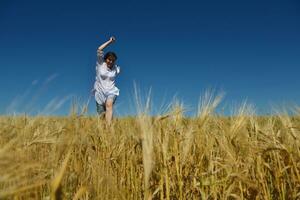 giovane donna nel campo di grano in estate foto