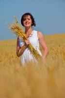giovane donna nel campo di grano in estate foto