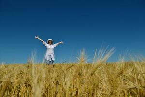 giovane donna nel campo di grano in estate foto