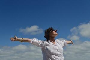 felice giovane donna con le braccia allargate al cielo foto