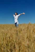 giovane donna nel campo di grano in estate foto