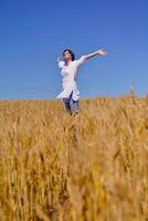 giovane donna nel campo di grano in estate foto