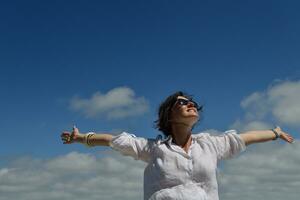 giovane donna con le braccia allargate al cielo foto