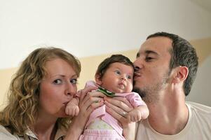 interno ritratto con contento giovane famiglia e carino poco bambino foto