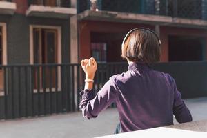 felice giovane donna asiatica che ascolta musica con le cuffie foto