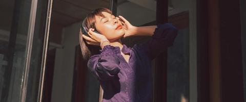 felice giovane donna asiatica che ascolta la musica foto