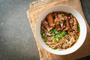 noodles di coscia di maiale in umido in zuppa marrone foto