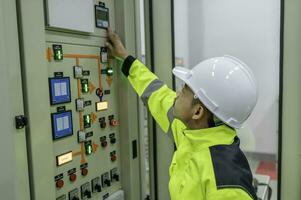 elettrico ingegnere uomo controllo voltaggio a il energia distribuzione Consiglio dei ministri nel il controllo stanza, preventiva Manutenzione annuale, Tailandia elettricista Lavorando a azienda foto